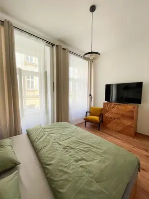 a bedroom with a bed and a flat screen tv at Vantisch Old Town Apartment in Prague