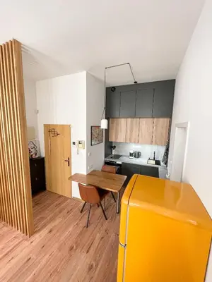 a kitchen with a table and a yellow refrigerator at Vantisch Old Town Apartment in Prague