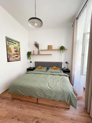 a bedroom with a bed with a green comforter at Vantisch Old Town Apartment in Prague