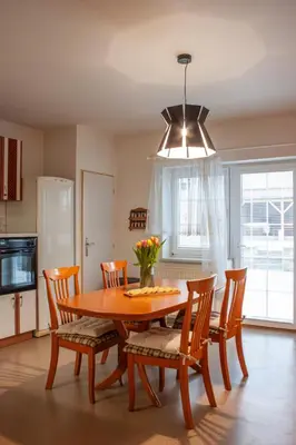 a dining room with a wooden table and white chairs at Apartmán se společným bazénem Zlonice in Zlonice