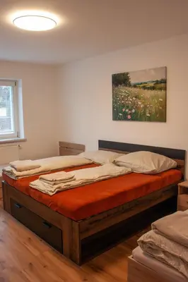 a room with two beds and a tv on the wall at Apartmán se společným bazénem Zlonice in Zlonice