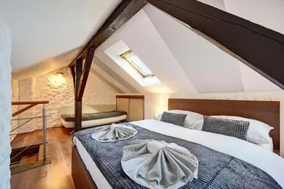 a attic bedroom with a bed with a towel on it at Đã Về - Đã Tới in Prague