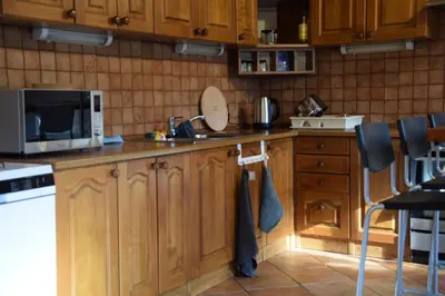 a kitchen with wooden cabinets and a microwave at Đã Về - Đã Tới in Prague