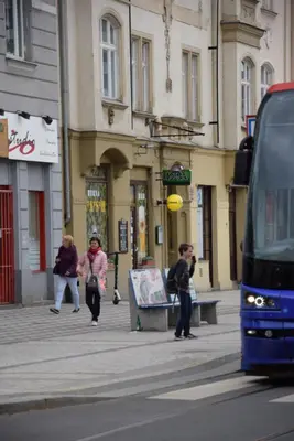 a group of people on a city street with a bus at Đã Về - Đã Tới in Prague