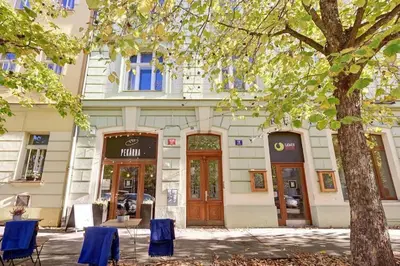 a building with blue chairs in front of it at Đã Về - Đã Tới in Prague