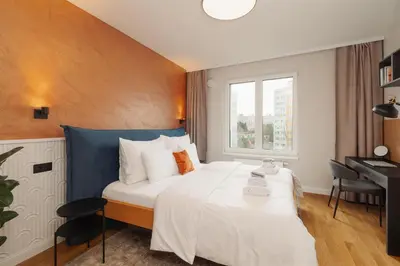 a bedroom with a large white bed and a desk at Luxury Sunny Home - Free Garage, Metro, Balcony, PS5, 2nd parking on request in Prague