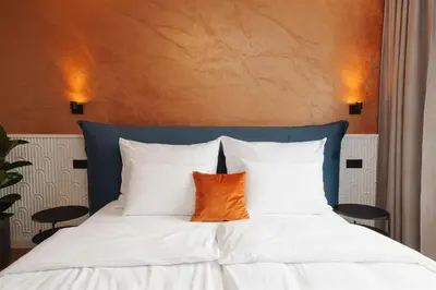 a white bed with a brown pillow on it at Luxury Sunny Home - Free Garage, Metro, Balcony, PS5, 2nd parking on request in Prague