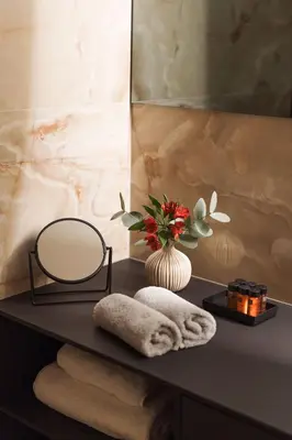 a table with a mirror and towels and a vase with flowers at Luxury Sunny Home - Free Garage, Metro, Balcony, PS5, 2nd parking on request in Prague
