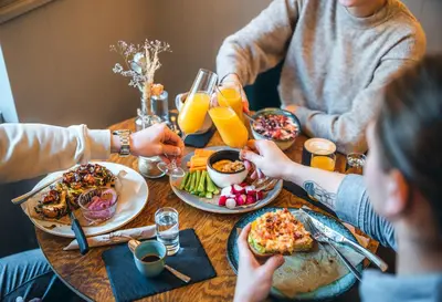 a group of people sitting around a table eating food at Accordion Boutique Hotel & Premium Suites in Prague