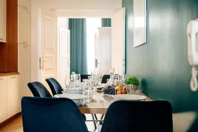 a dining room with a table and blue chairs at Wagnerstays Royal Billiard Residence in Prague