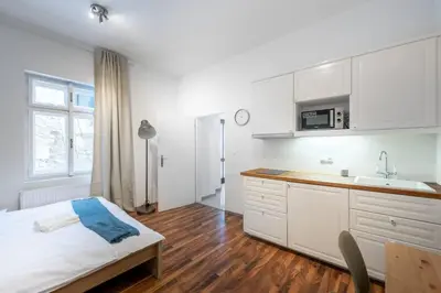 a white kitchen with a bed and a sink at Adorable Cozy Studio in Central Prague in Prague