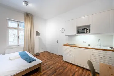 a white kitchen with a bed and a sink at Adorable Cozy Studio in Central Prague in Prague