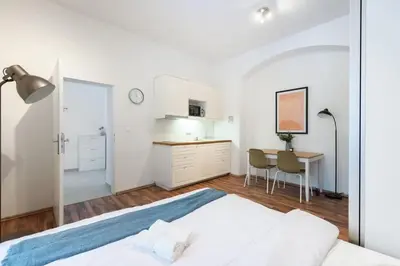 a white bedroom with a bed and a desk at Adorable Cozy Studio in Central Prague in Prague