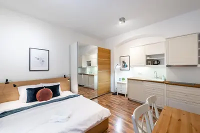 a bedroom with a large bed and a kitchen at Beautiful Cozy Studio Gem near Old Town in Prague