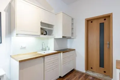 a kitchen with white cabinets and a sink at Beautiful Cozy Studio Gem near Old Town in Prague