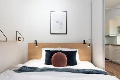 a bedroom with a white bed with a wooden headboard at Beautiful Cozy Studio Gem near Old Town in Prague