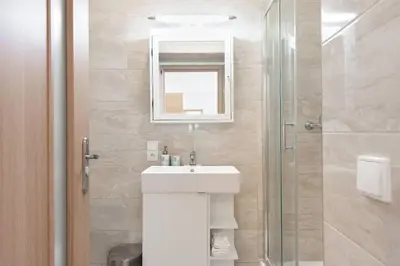 a bathroom with a sink and a glass shower at Beautiful Cozy Studio Gem near Old Town in Prague