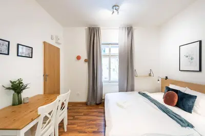 a bedroom with a white bed and a wooden table at Beautiful Cozy Studio Gem near Old Town in Prague