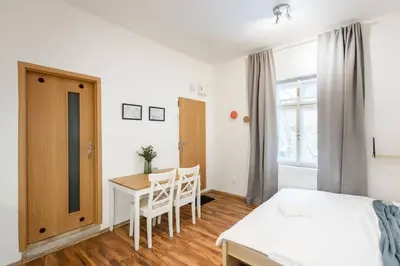 a bedroom with a bed and a table and chairs at Beautiful Cozy Studio Gem near Old Town in Prague
