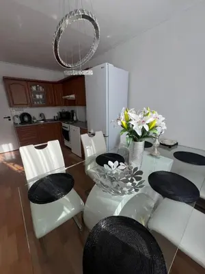 a dining room with a glass table and white chairs at Útulný prostorný tichý byt v blízkosti centra in Prague