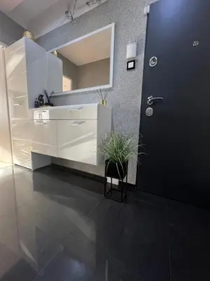 a bathroom with a large mirror and a black door at Útulný prostorný tichý byt v blízkosti centra in Prague