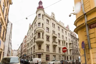 a large white building on a city street with cars at Prague Days - Three-bedroom Apartment with Balcony in Prague