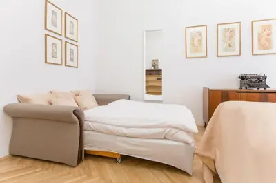 a bedroom with a bed and a couch at Prague Days - Three-bedroom Apartment with Balcony in Prague
