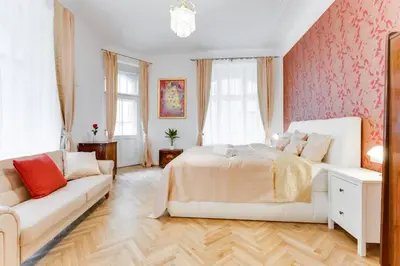 a bedroom with a white bed and a couch at Prague Days - Three-bedroom Apartment with Balcony in Prague