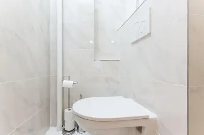 a white bathroom with a toilet and a shower at Prague Days - Three-bedroom Apartment with Balcony in Prague