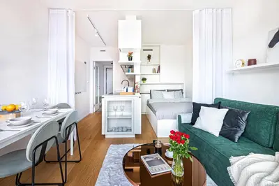 a living room with a green couch and a table at Prague Days - Studio Apartment with Garage Parking and Balcony in Prague