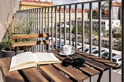 a wooden table with an open book and a cup of coffee and a book at Prague Days - Studio Apartment with Garage Parking and Balcony in Prague