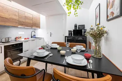 a kitchen with a black table with chairs and a dining room at Prague Days - Studio with Netflix at Náměstí Míru in Prague