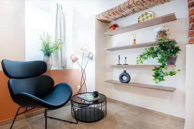 a living room with a chair and shelves at Prague Days - Studio with Netflix at Náměstí Míru in Prague