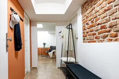 a hallway with a room with a brick wall at Prague Days - Studio with Netflix at Náměstí Míru in Prague