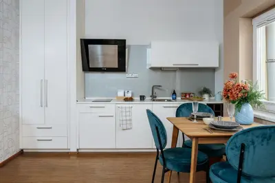 a kitchen with a wooden table and blue chairs at Prague Days - Studio in a prime location with AC close to the Charles Bridge in Prague