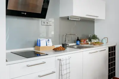 a white kitchen with a sink and a microwave at Prague Days - Studio in a prime location with AC close to the Charles Bridge in Prague