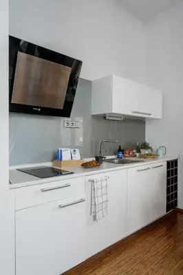 a white kitchen with a sink and a microwave at Prague Days - Studio in a prime location with AC close to the Charles Bridge in Prague