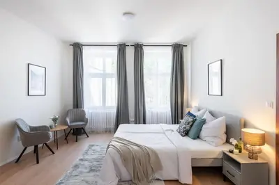 a bedroom with a white bed and a table and chairs at Spacious Luxury Old Town 2BR Retreat in Prague