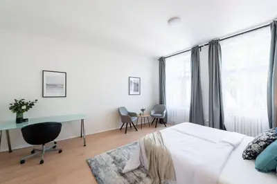 a bedroom with a bed and a desk and a window at Spacious Luxury Old Town 2BR Retreat in Prague