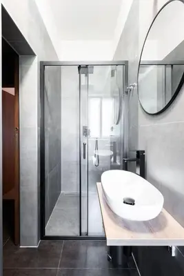 a bathroom with a sink and a shower with a mirror at Spacious Luxury Old Town 2BR Retreat in Prague
