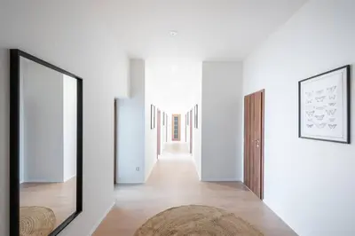 a hallway with white walls and a mirror at Spacious Luxury Old Town 2BR Retreat in Prague