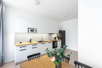 a kitchen with white cabinets and a wooden table at Spacious Luxury Old Town 2BR Retreat in Prague