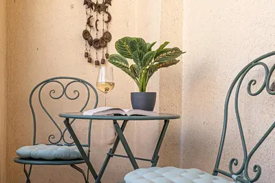 a table with a book and a plant and two chairs at Prague Days - Apartment with 2 Bedrooms and 2 Balconies in Vinohrady in Prague