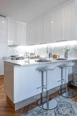 a kitchen with white cabinets and a large island at Prague Days - Apartment with 2 Bedrooms and 2 Balconies in Vinohrady in Prague