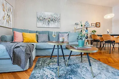 a living room with a blue couch and two tables at Prague Days - Apartment with 2 Bedrooms and 2 Balconies in Vinohrady in Prague
