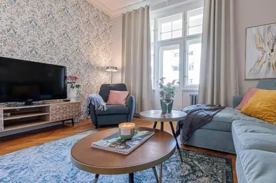 a living room with a couch and a tv at Prague Days - Apartment with 2 Bedrooms and 2 Balconies in Vinohrady in Prague