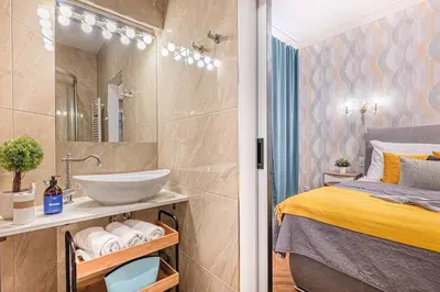 a small bathroom with a bed and a sink at Prague Days - Apartment with 2 Bedrooms and 2 Balconies in Vinohrady in Prague