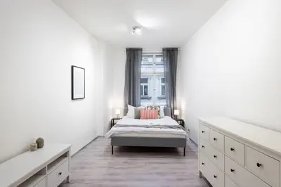 a white bedroom with a bed and a window at Timeless Charming Studio near Old Town in Prague