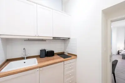 a kitchen with white cabinets and a sink at Timeless Charming Studio near Old Town in Prague