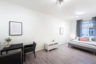 a white room with a bed and a desk at Timeless Charming Studio near Old Town in Prague